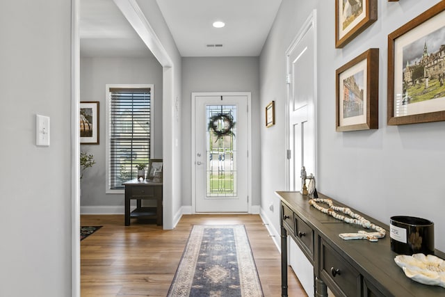 entryway featuring healthy amount of natural light, light wood-type flooring, and baseboards