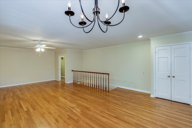 unfurnished room featuring a chandelier, ornamental molding, light wood finished floors, a ceiling fan, and baseboards