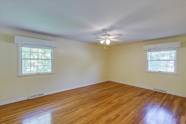 unfurnished room featuring a ceiling fan, light wood-type flooring, and baseboards