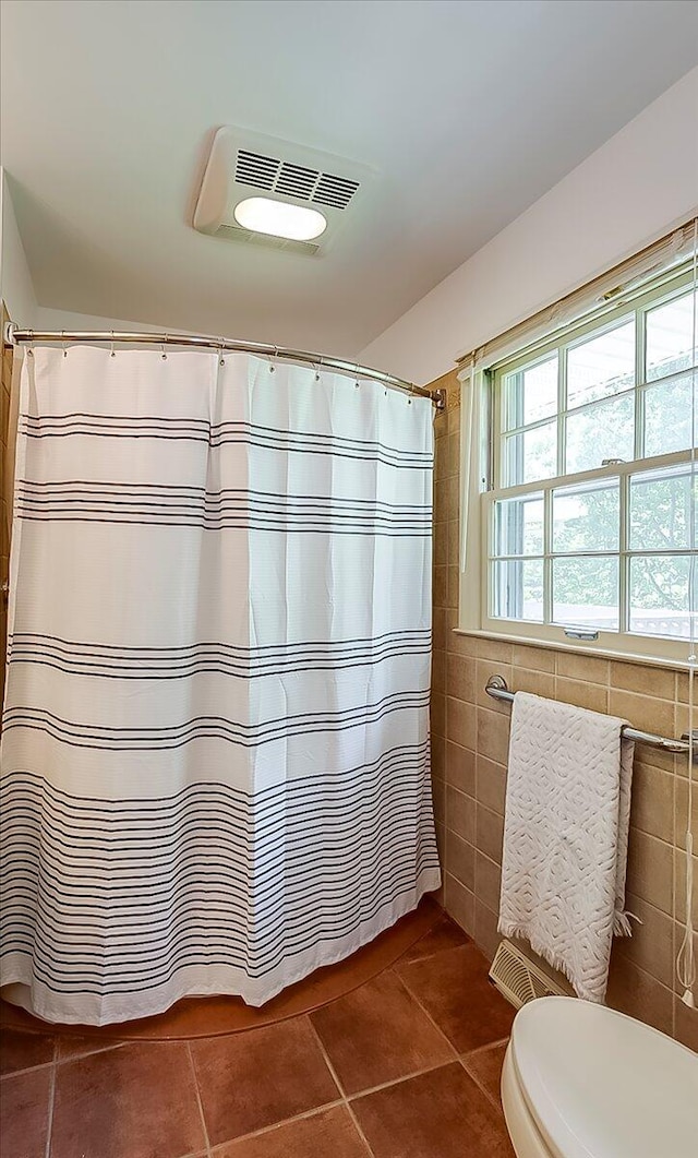 bathroom featuring tile walls, tile patterned floors, toilet, and a shower with shower curtain