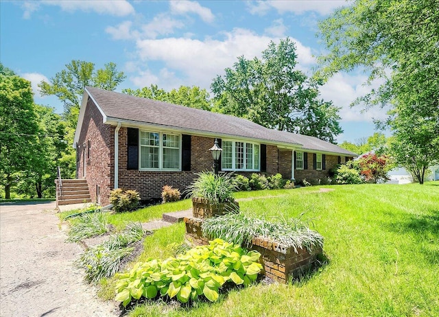 ranch-style house with a front yard and brick siding
