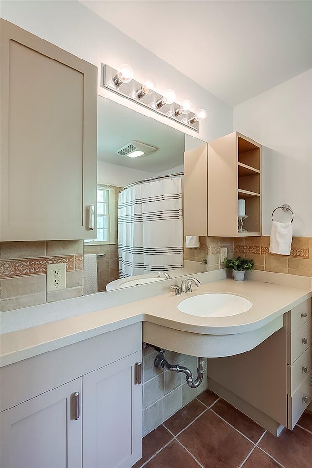 bathroom with tile patterned floors, decorative backsplash, and a sink