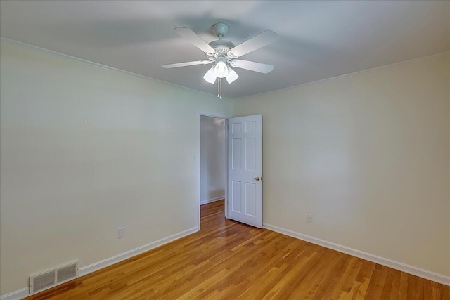 spare room with light wood-style floors, baseboards, ceiling fan, and ornamental molding