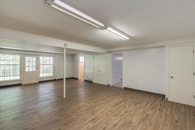 basement featuring wood finished floors and crown molding