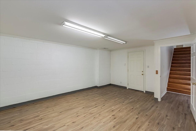 unfurnished room with wood finished floors, stairway, and baseboards