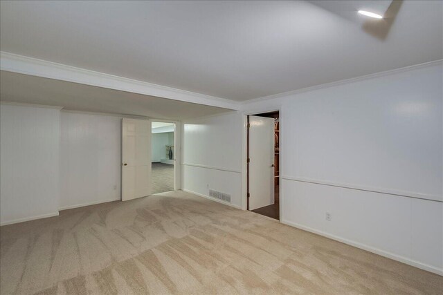 spare room featuring carpet flooring, crown molding, and baseboards
