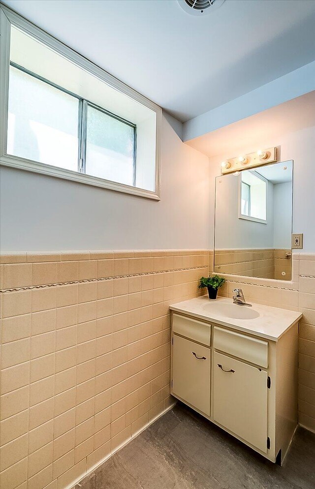 bathroom with tile walls, wainscoting, and vanity