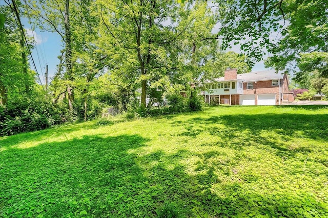 view of green lawn with a garage