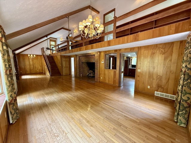 118 Timber Ln, Morehead, KY 40351 - unfurnished living room with wood-type flooring, a chandelier, wood walls, stairway, and a fireplace