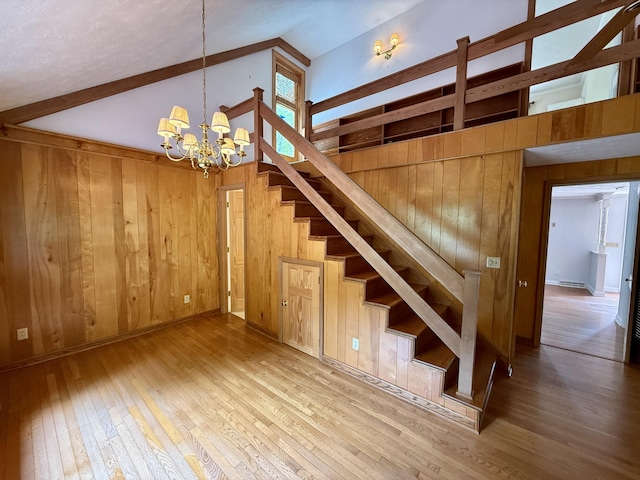 118 Timber Ln, Morehead, KY 40351 - stairs with wood walls, vaulted ceiling, a chandelier, and hardwood / wood-style floors