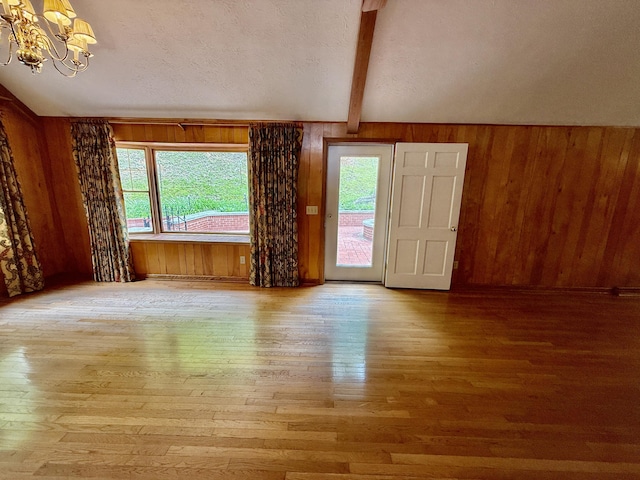 118 Timber Ln, Morehead, KY 40351 - spare room featuring hardwood / wood-style floors, plenty of natural light, a chandelier, beamed ceiling, and wood walls