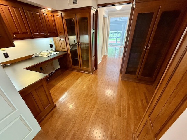 118 Timber Ln, Morehead, KY 40351 - kitchen featuring light wood-style floors, glass insert cabinets, brown cabinetry, and ornamental molding
