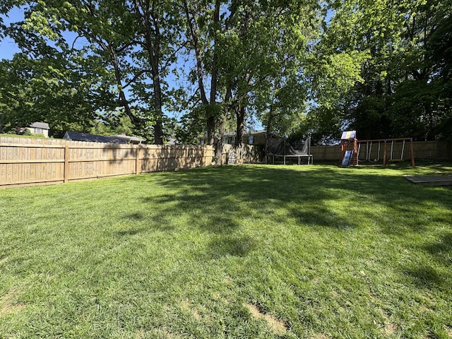 view of yard featuring a trampoline and a playground