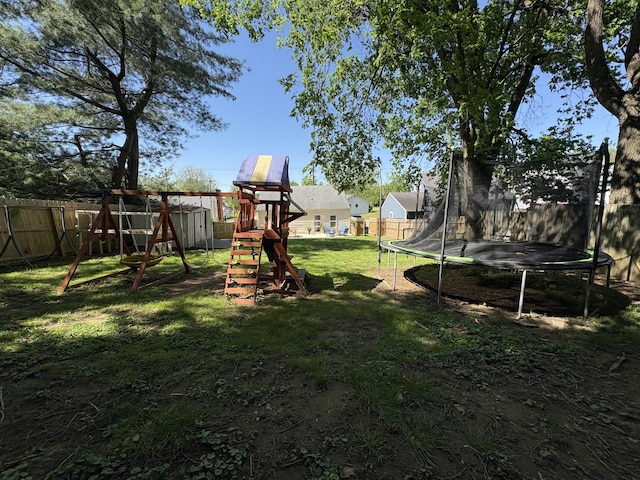 view of yard featuring a trampoline and a playground