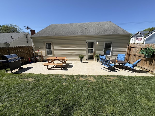 rear view of house with a patio area and a shingled roof