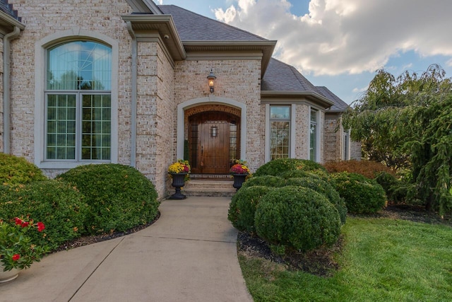 150 Old Woods Dr, Nicholasville, KY 40356 - view of exterior entry with brick siding, roof with shingles, and a yard