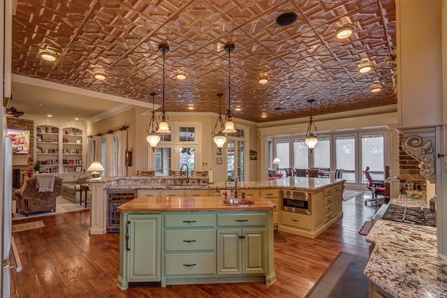 150 Old Woods Dr, Nicholasville, KY 40356 - kitchen featuring green cabinetry, a large island, ornamental molding, beverage cooler, and a sink