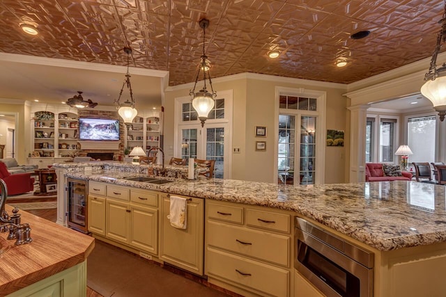 150 Old Woods Dr, Nicholasville, KY 40356 - kitchen featuring open floor plan, a sink, stainless steel microwave, cream cabinets, and crown molding