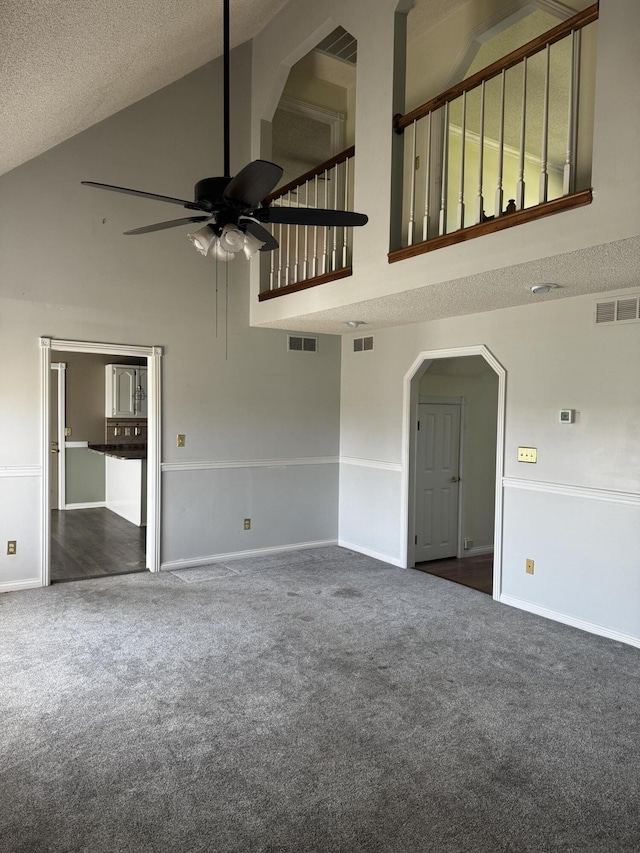 400 Natures Pointe Dr, Somerset, KY 42503 - unfurnished living room with high vaulted ceiling, carpet flooring, a ceiling fan, arched walkways, and a textured ceiling