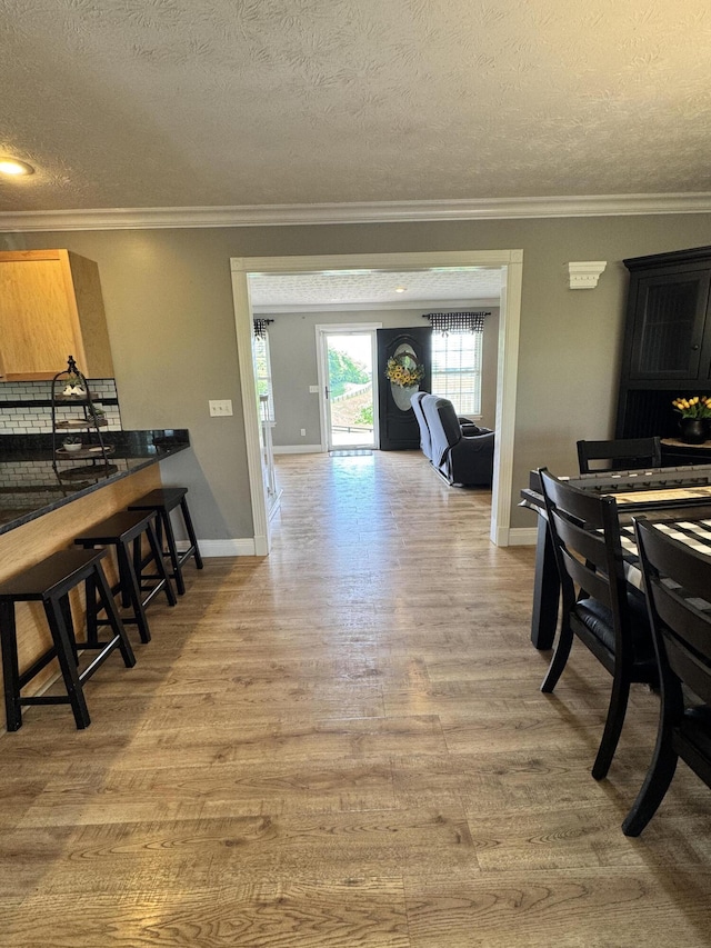 2230 Perryville Rd, Harrodsburg, KY 40330 - dining space featuring crown molding, light wood-style flooring, a textured ceiling, and baseboards