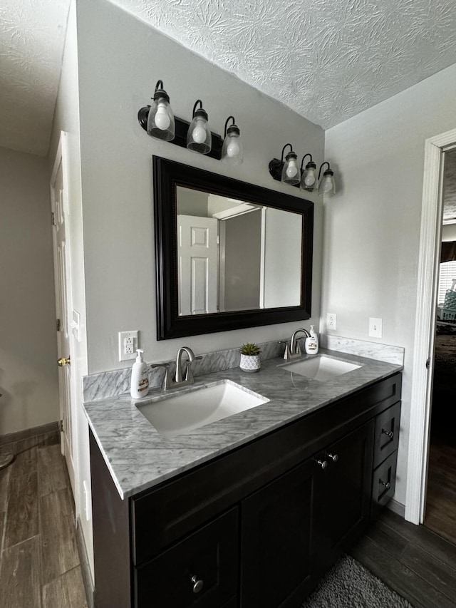 2230 Perryville Rd, Harrodsburg, KY 40330 - bathroom with wood finished floors, double vanity, a textured ceiling, and baseboards