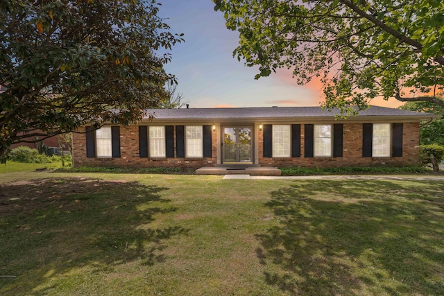 ranch-style house featuring a front lawn and brick siding
