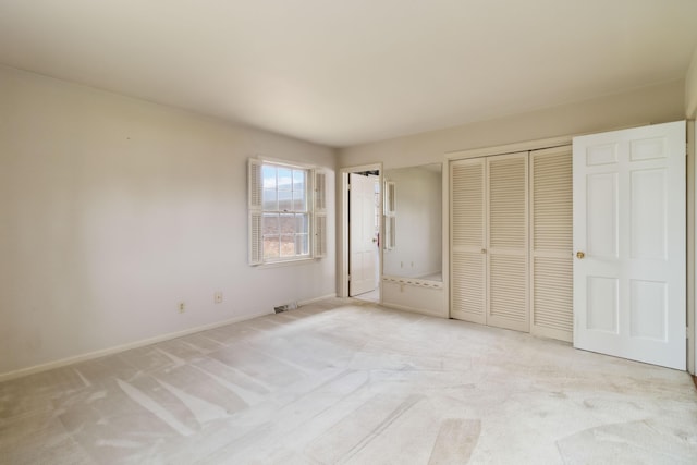 unfurnished bedroom with light colored carpet, baseboards, and a closet
