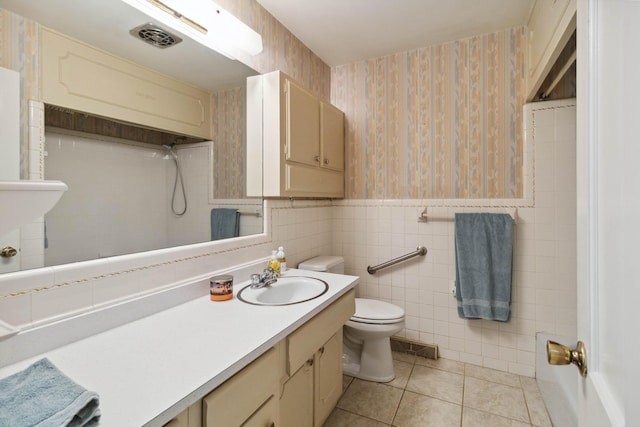 full bath with wallpapered walls, toilet, tile patterned flooring, a wainscoted wall, and vanity