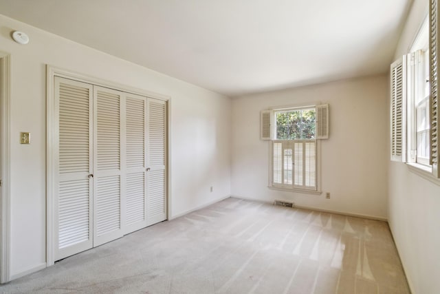 unfurnished bedroom with carpet, a closet, and baseboards