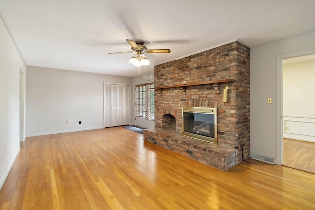 unfurnished living room with wood finished floors, ceiling fan, a fireplace, and baseboards