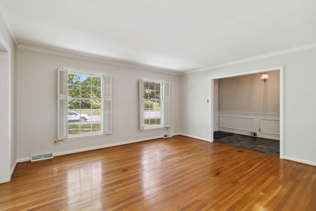 spare room featuring ornamental molding, wood finished floors, and baseboards
