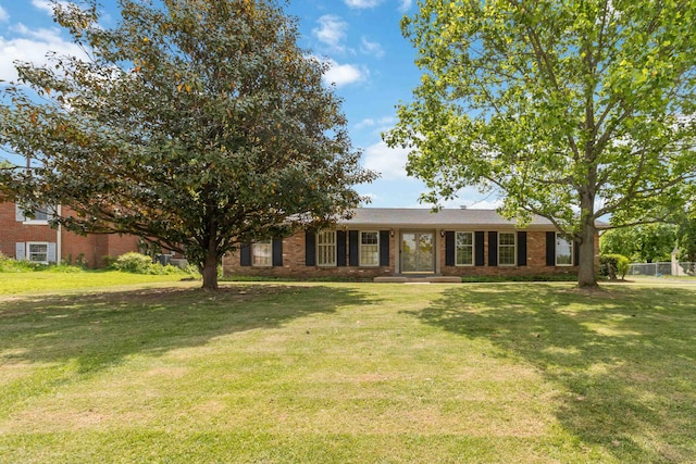 ranch-style house featuring brick siding and a front yard