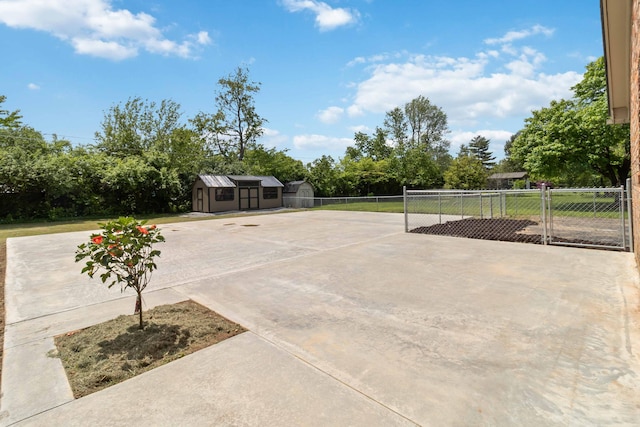 view of patio featuring a storage unit, fence, an outdoor structure, and view of scattered trees