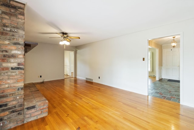 unfurnished living room featuring a ceiling fan and wood finished floors