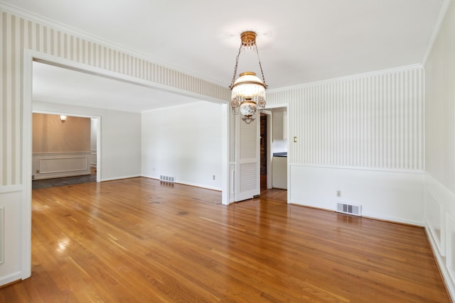 unfurnished dining area with light wood-style floors, a chandelier, and ornamental molding