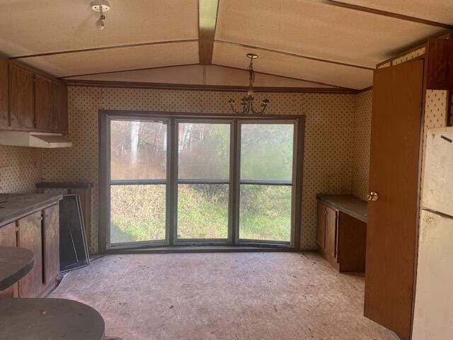 unfurnished dining area featuring vaulted ceiling and light carpet