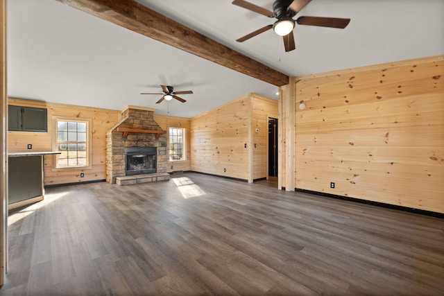 740 N Main St, Stanton, KY 40380 - unfurnished living room featuring a ceiling fan, wood walls, dark wood-style floors, and a stone fireplace