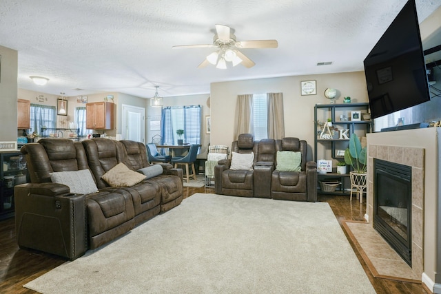 3065 Caddis Ln, Lexington, KY 40511 - living room with wood finished floors, a tiled fireplace, ceiling fan, and a textured ceiling