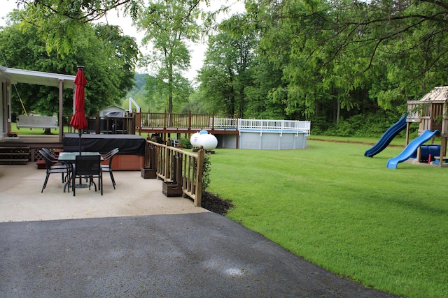 199 Langnau Rd, London, KY 40741 - view of green lawn featuring a hot tub, an outdoor pool, a playground, a patio area, and view of scattered trees