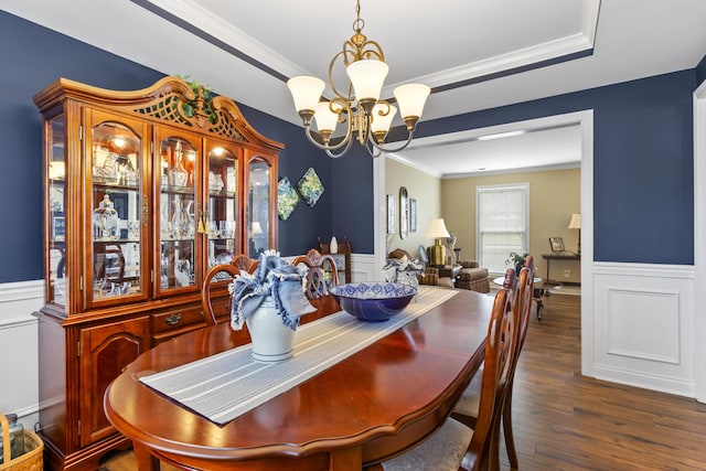dining space with a chandelier, wainscoting, ornamental molding, wood finished floors, and a decorative wall