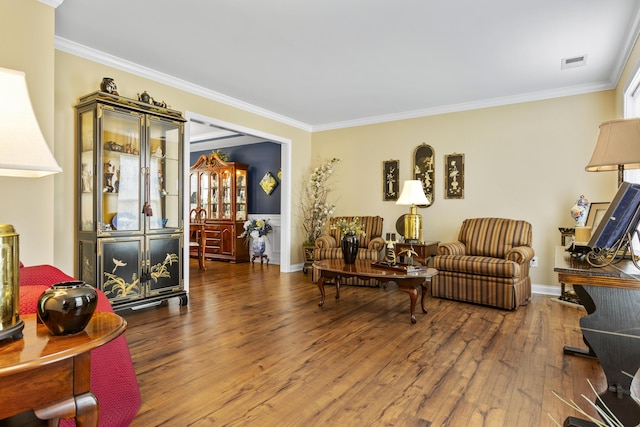 living area featuring ornamental molding, hardwood / wood-style floors, and baseboards