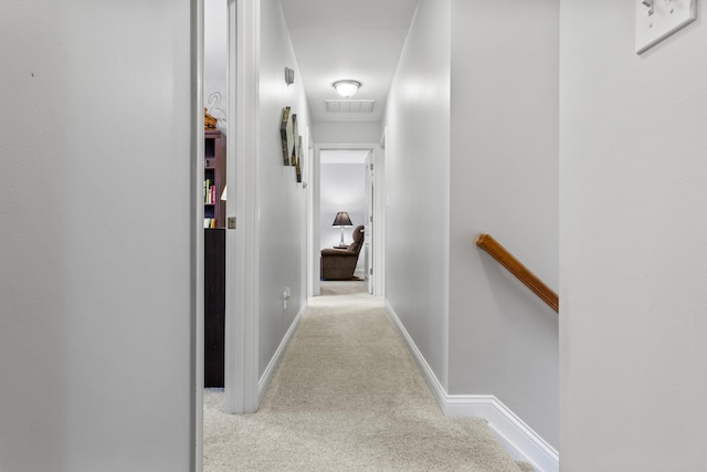 corridor with an upstairs landing, carpet, and baseboards