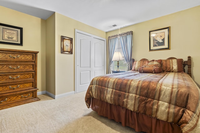 carpeted bedroom featuring a closet and baseboards