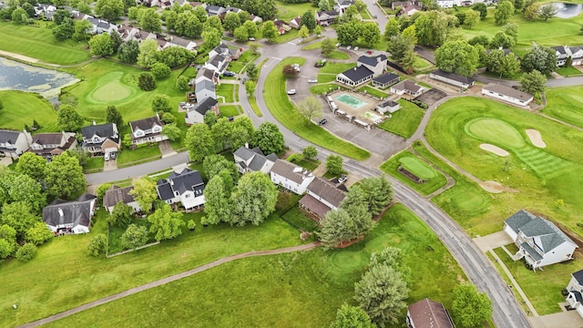 aerial view of property's location with nearby suburban area, a nearby body of water, and a golf club