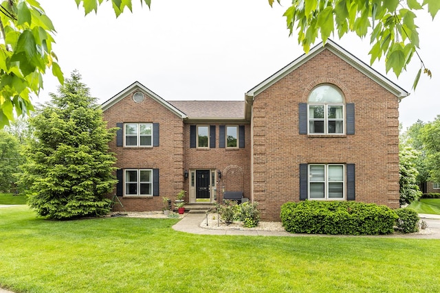 view of front of house featuring brick siding and a front lawn