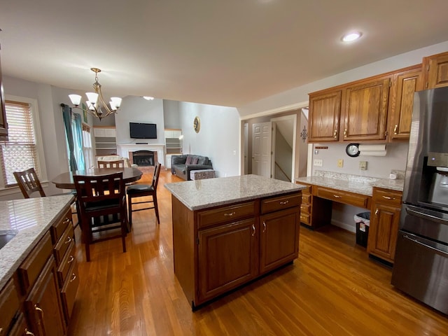 4120 Amberwood Ct, Lexington, KY 40513 - kitchen featuring stainless steel fridge, dark wood-type flooring, brown cabinets, a kitchen island, and light stone countertops