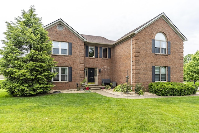 view of front of house with brick siding and a front yard