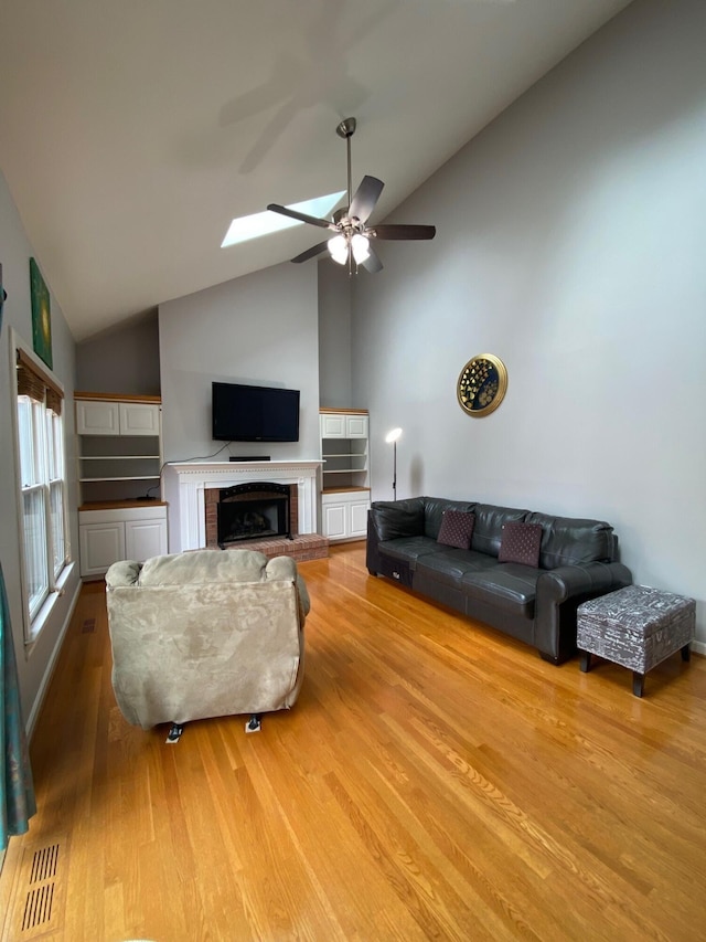 4120 Amberwood Ct, Lexington, KY 40513 - living area featuring a ceiling fan, wood finished floors, high vaulted ceiling, a fireplace, and a skylight