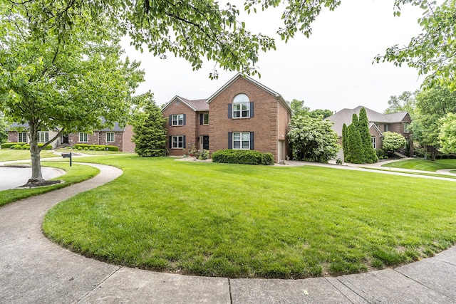 view of front of home featuring a front yard and brick siding