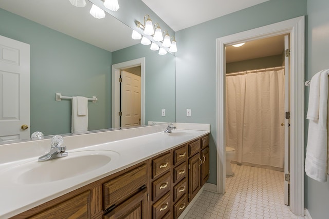 bathroom with toilet and double vanity
